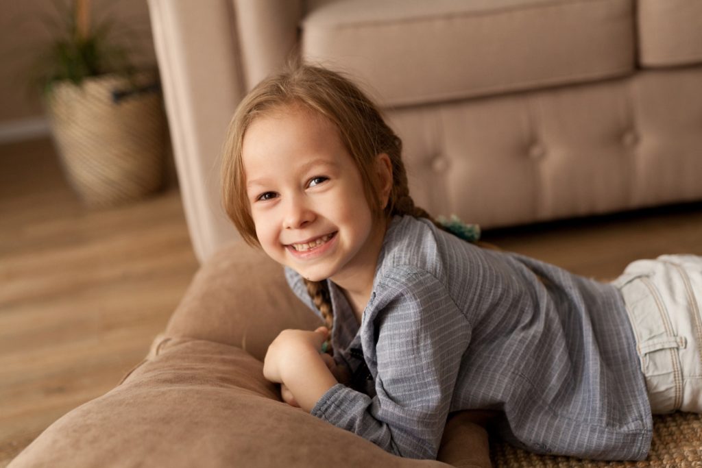 Closeup of young girl smiling while relaxing on couch
