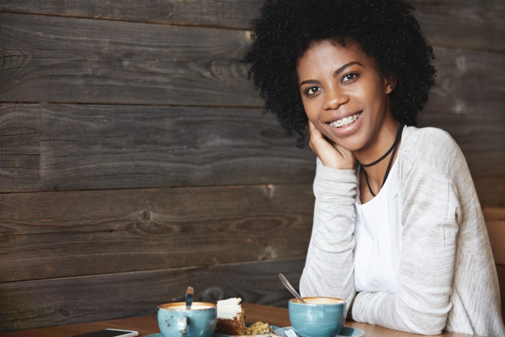 Woman smiling with adult braces in coffee shop